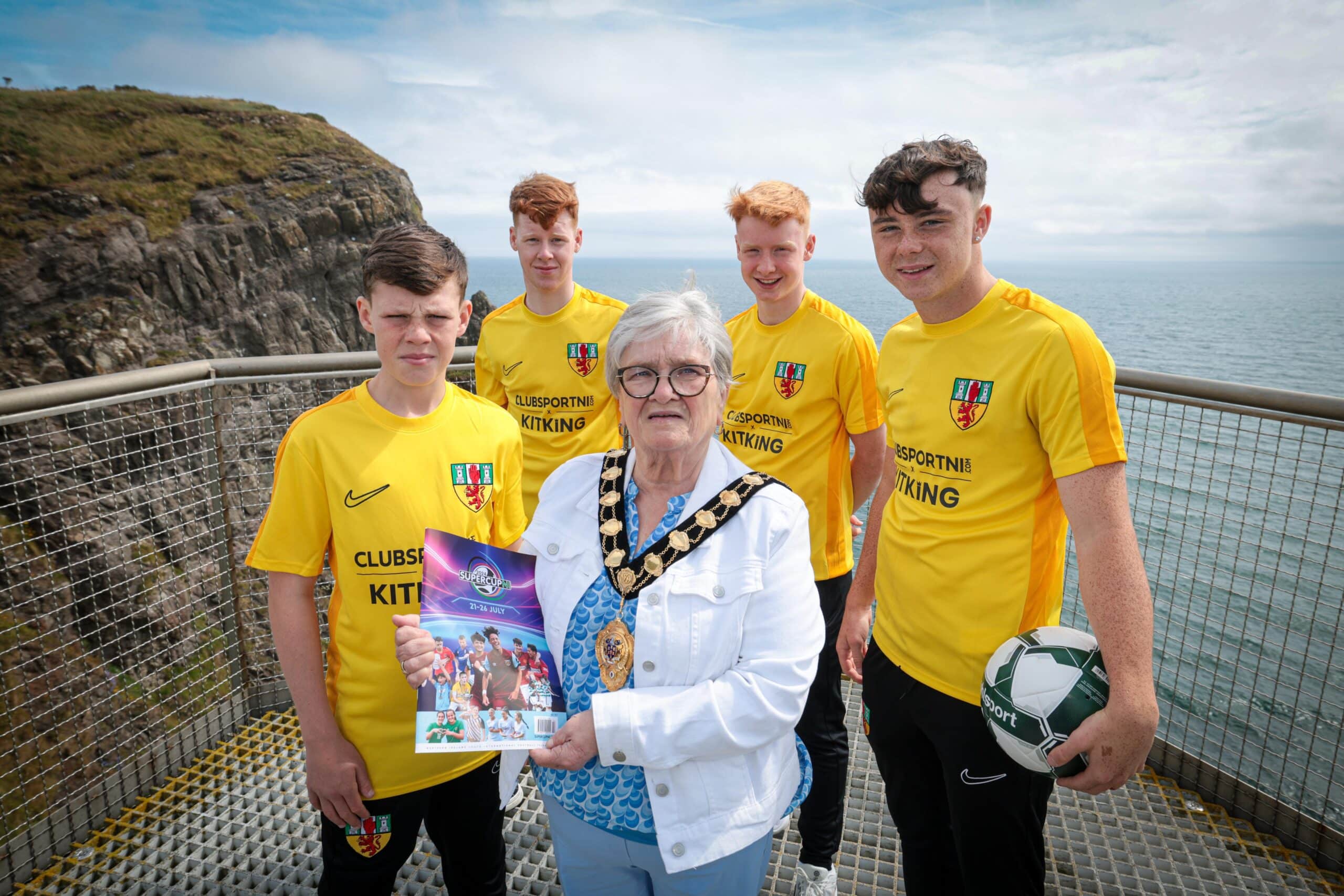 Mid and East Antrim Borough Council is wishing local and international teams competing at the 2024 SuperCupNI the best of luck as it gets set to host some of the world’s most talented young footballers as part of this year’s tournament. The 2024 SuperCupNI, celebrating its 41st year, will kick off with its traditional welcome parade and opening ceremony in Coleraine on Sunday 21st July before an action-packed week of football gets underway on Monday 22nd July. The thrilling action will end with Finals Day on Friday 26th July.

Mayor of Mid & East Antrim Borough, Alderman Beth Adger MBE is pictured visiting the Borough’s Gobbins Coastal Cliff Path to meet Co. Antrim SuperCupNI Premier and Junior Squad members Oisin Morgan, Cohen Beattie, Finlay Millar and Jayden Charnley in the build-up to the tournament’s kick-off.