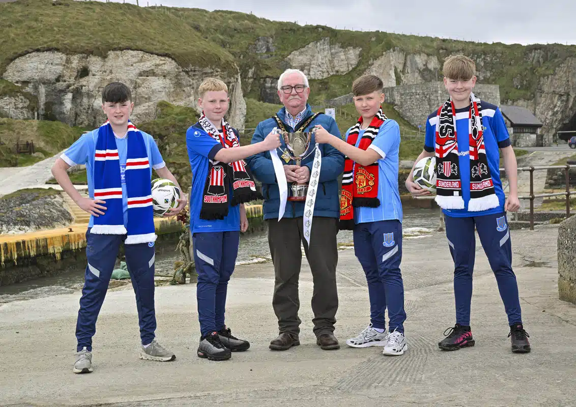 Ballymena United 2013s players Cole Logan, Curtis McKeown, Mason Buxton and William Shannon are pictured at Ballintoy Harbour alongside Mayor of Causeway Coast and Glens, Councillor Oliver McMullan, as the Budget Energy SuperCupNI confirms its 2026 Boys’ Premier Section line-up, featuring global heavyweights Manchester United and Sunderland, alongside Scottish giants Rangers and reigning champions Southampton.