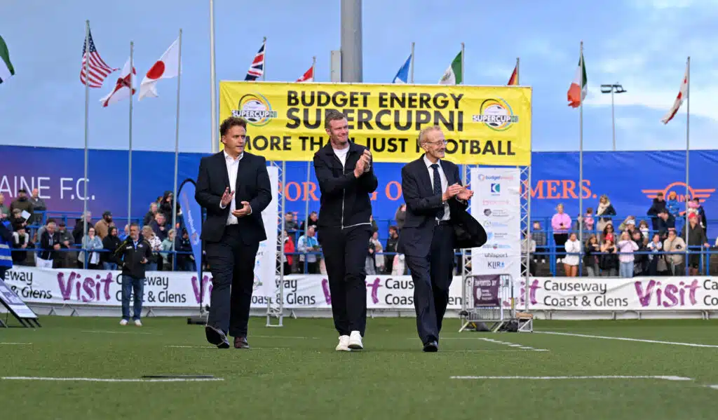 26th July 2026
Press Eye - Belfast - Northern Ireland - 

Thousands of spectators lined the streets of Coleraine and packed the stands and terraces of the Coleraine Showgrounds to give a rousing welcome to over 1,200 elite young footballers from around the world as Northern Ireland legend Chris Brunt  kicked-off an action-packed week of youth football with the official launch of the 2026 SuperCupNI.
Karl Bradley from Budget Energy , Chris Brunt and Victor Leonard pictured at tonights parade.

Picture by - Stephen Hamilton -Presseye